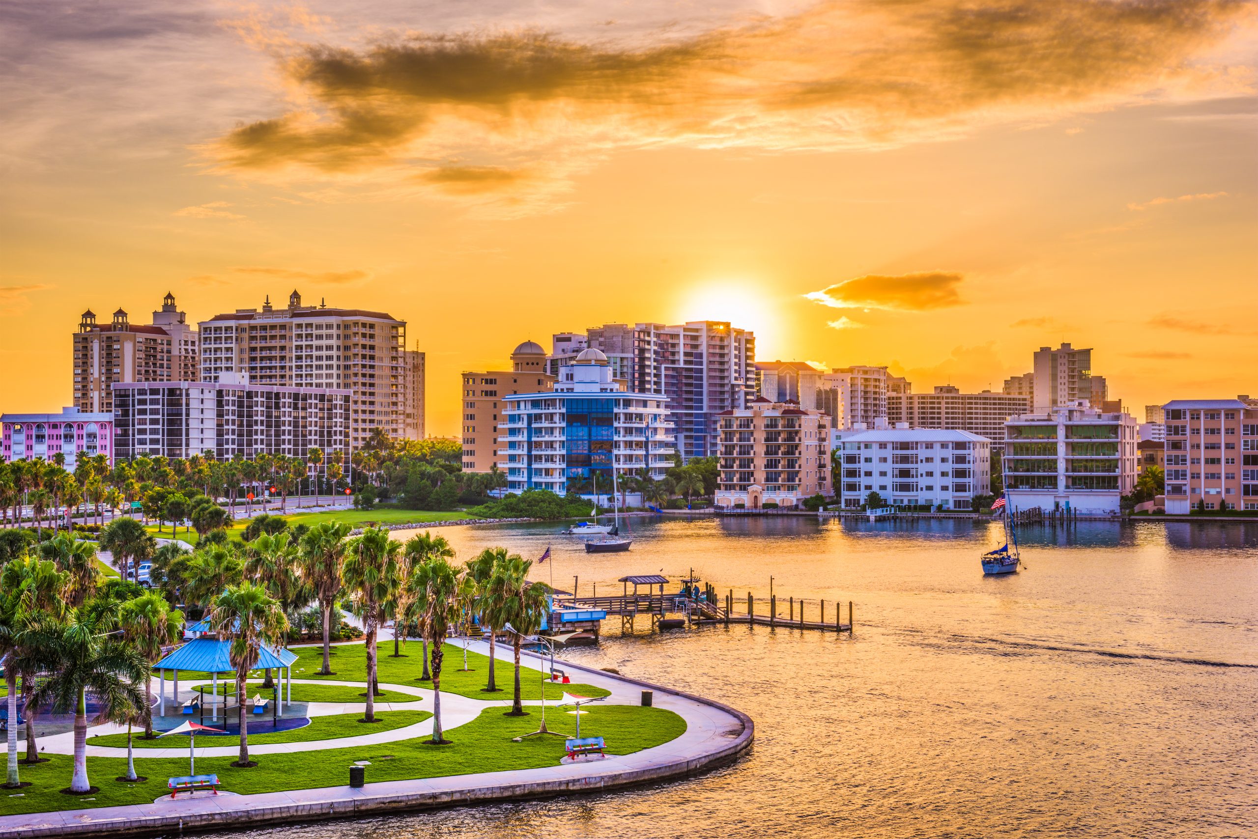 Aerial view of a coastal city with a vibrant sunset.