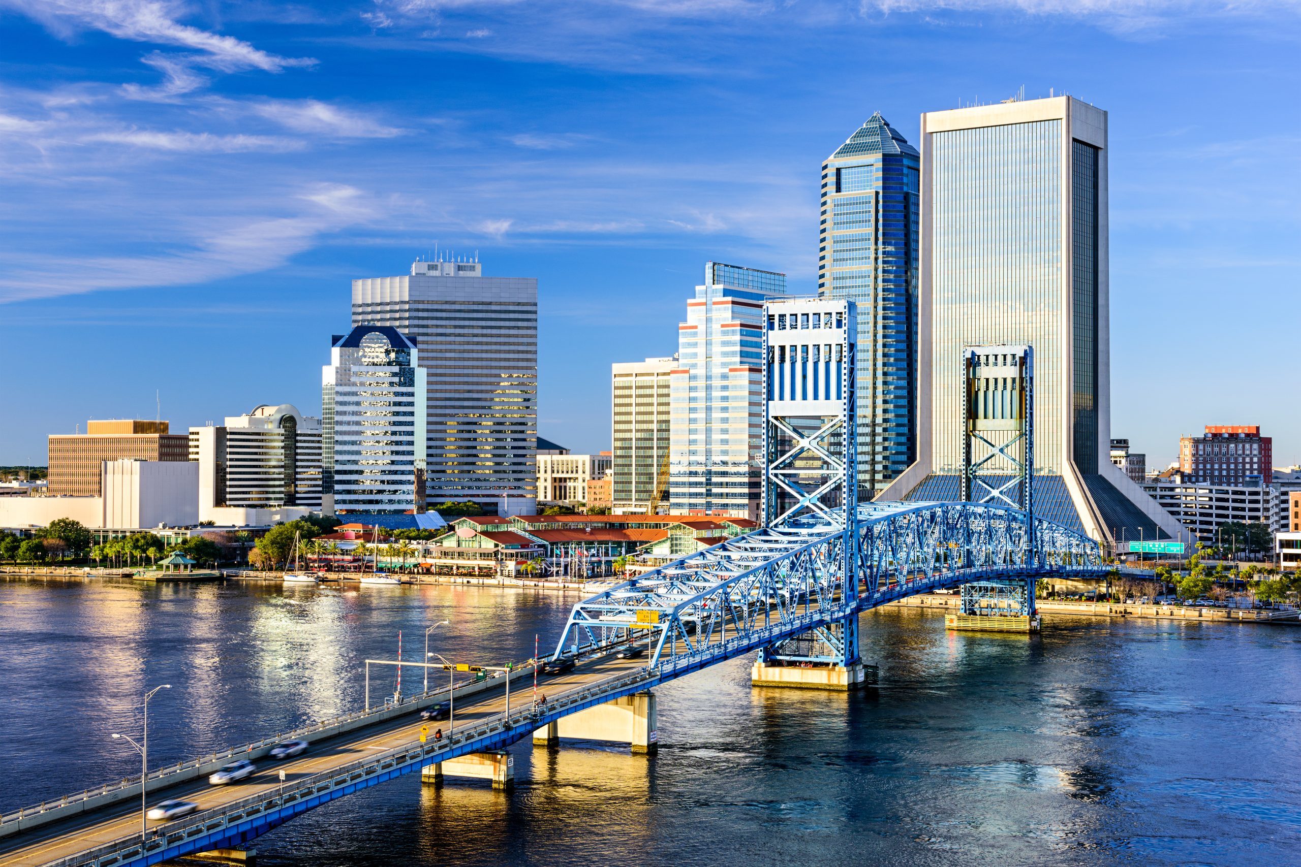 Aerial view of a city along a waterway with bridges and buildings.