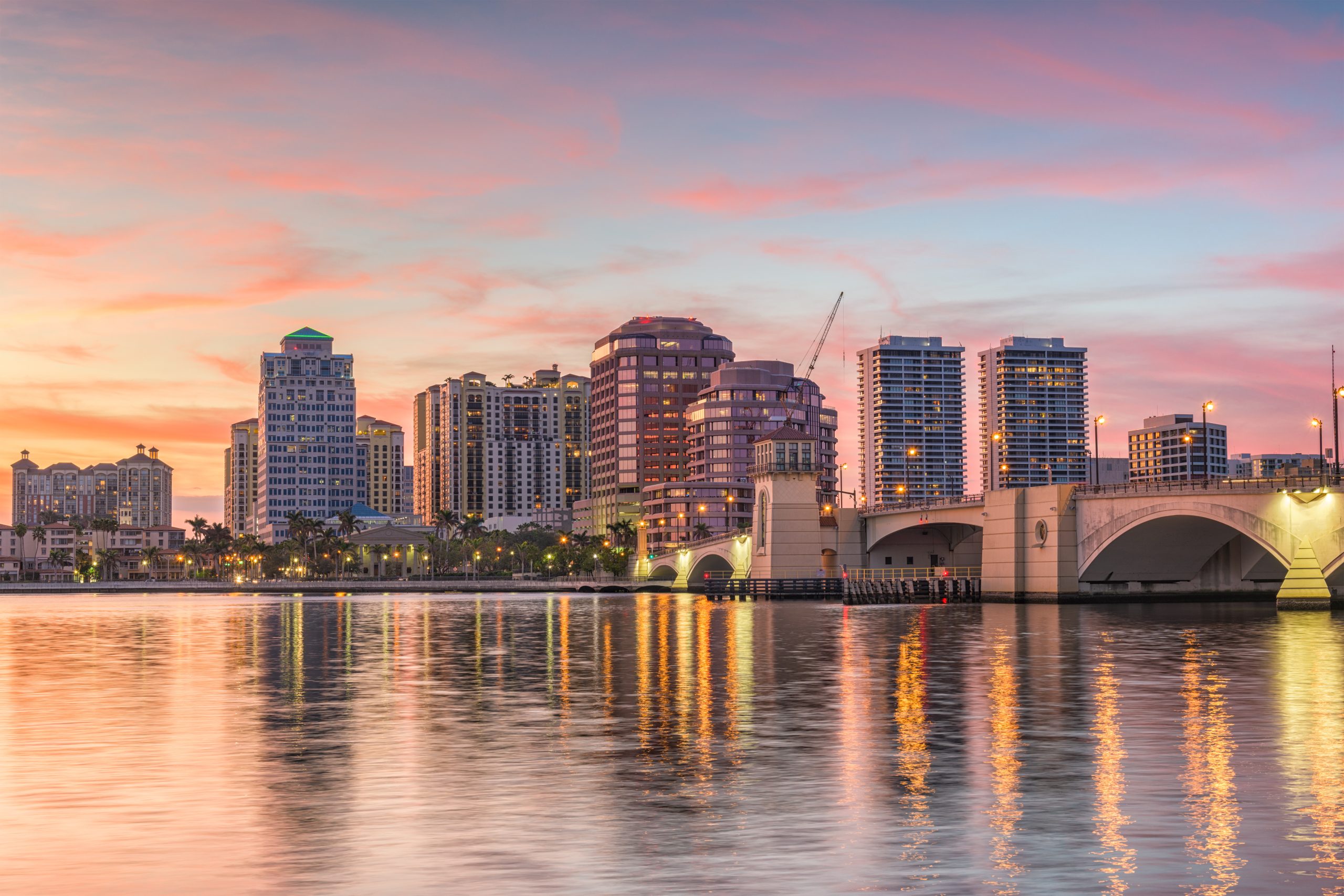 Aerial view of a cityscape by a river during sunset.