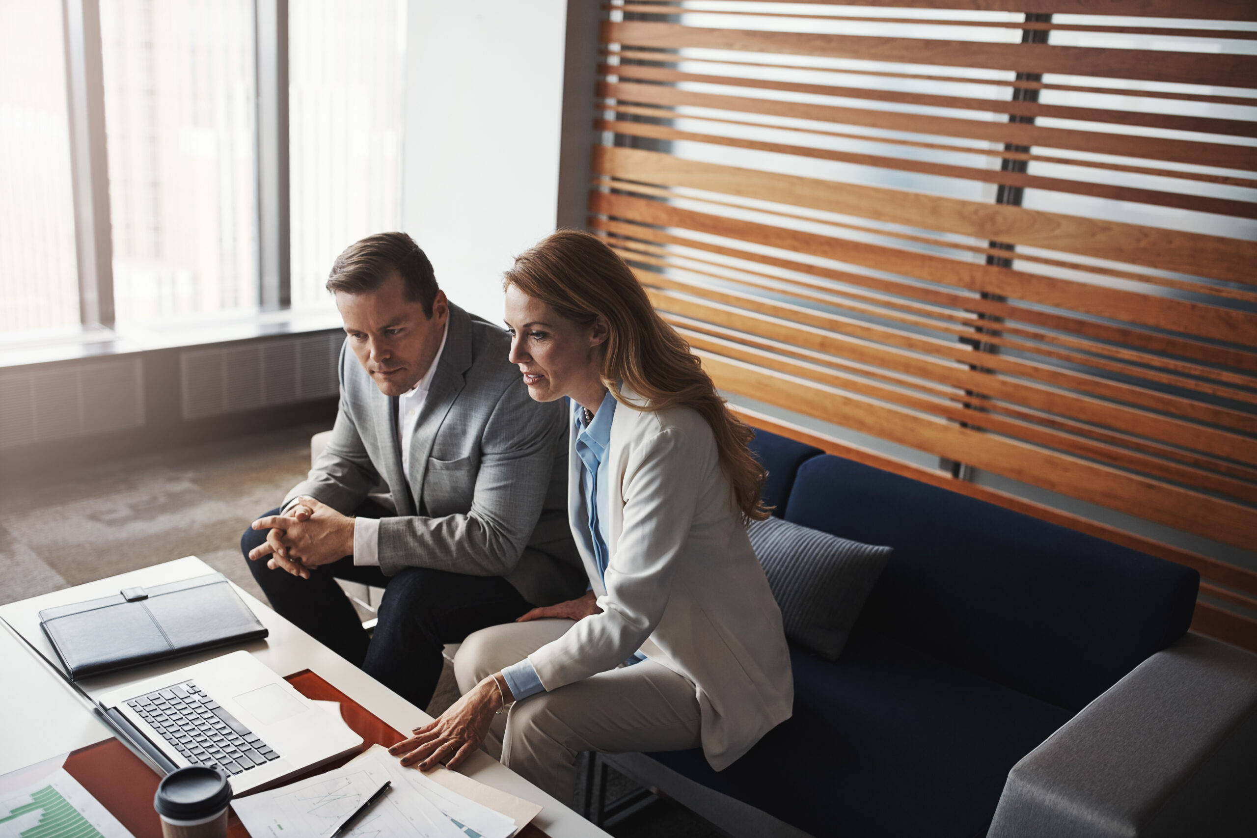 Laptop, coaching and business people in office meeting with finance, documents or investment research.